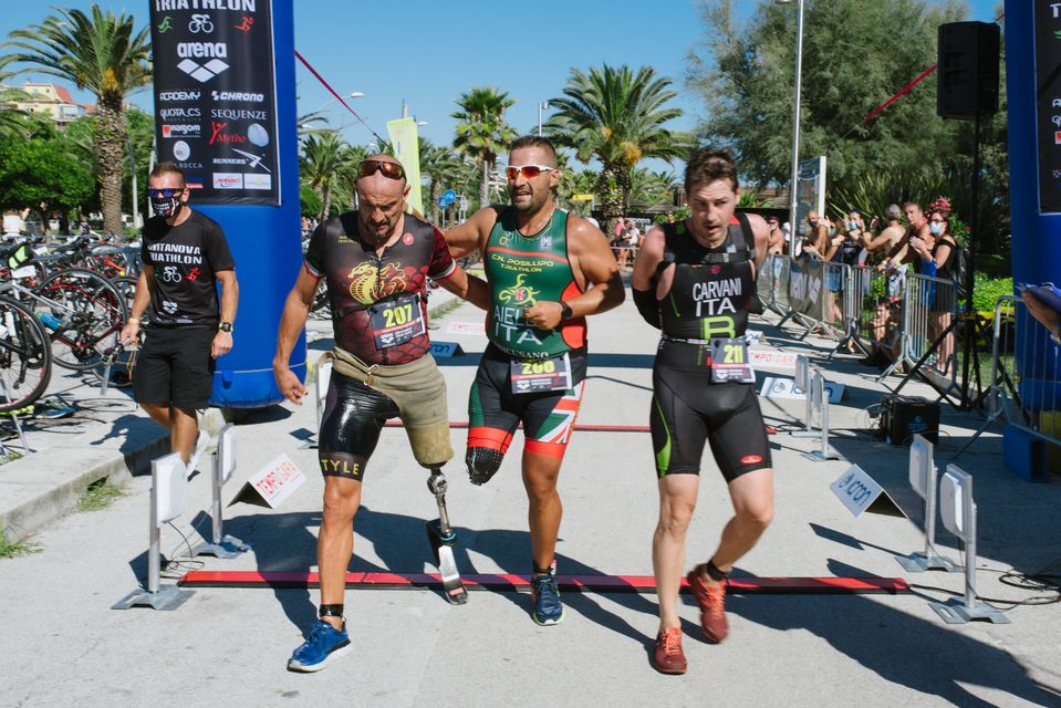 L'arrivo del paratriatleta Salvatore Aiello, sorretto dai suoi compagni di fatica Andrea Miniati e Alessandro Carvani Minetti, al Civitanova Triathlon del 6 settembre 2020